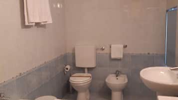 A bathroom with a bathtub, toilet, bidet, and sink.