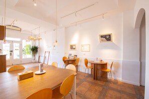 Relax in a stylish space with a large table, multiple chairs, and a cozy reading nook.