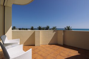 Enjoy the ocean view from this balcony with a wicker chair.