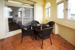 Enjoy a balcony with a round table and four chairs, offering a view of the surrounding residential area.