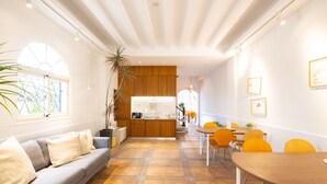 A modern interior with a sofa, dining table, and kitchen area. - OwlStay The Salt (Hualien City)