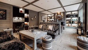 A modern living room with a sofa, armchairs, a coffee table, and a fireplace. - Le K2 Djola (Courchevel)