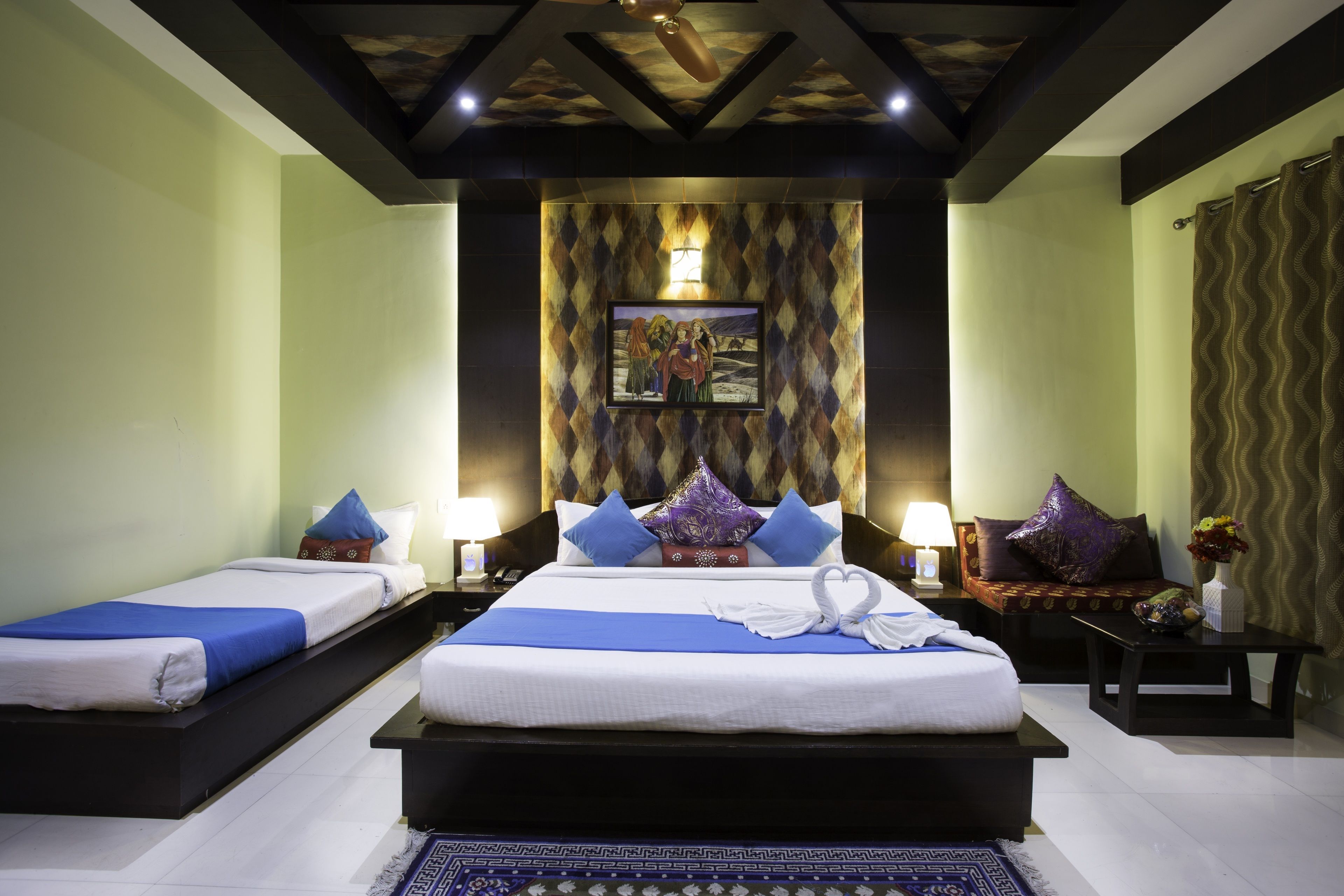 A hotel room with two beds, a large painting on the wall, and a patterned rug.