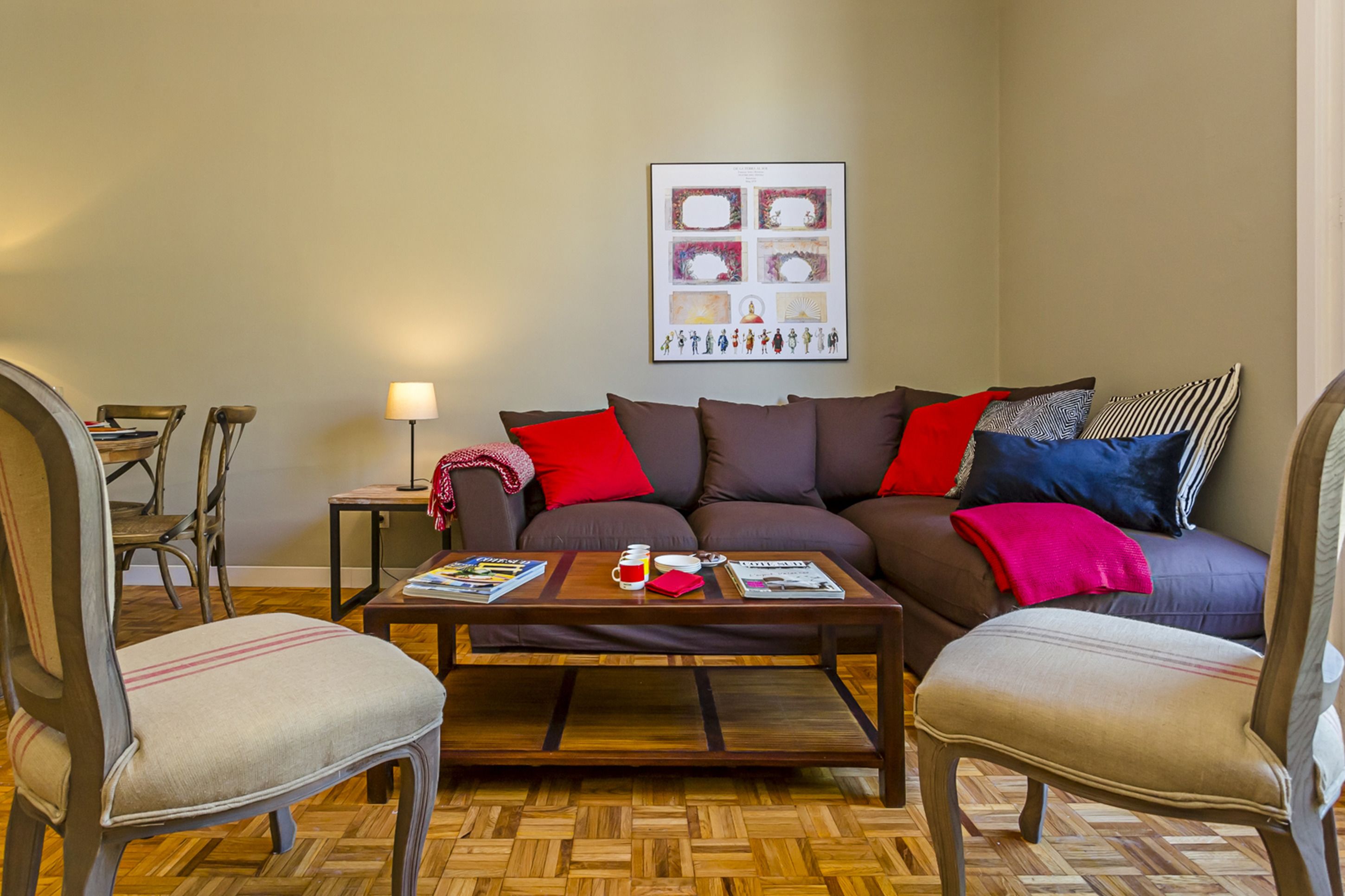 Un salon comprenant un canapé, deux fauteuils, une table basse et une lampe.