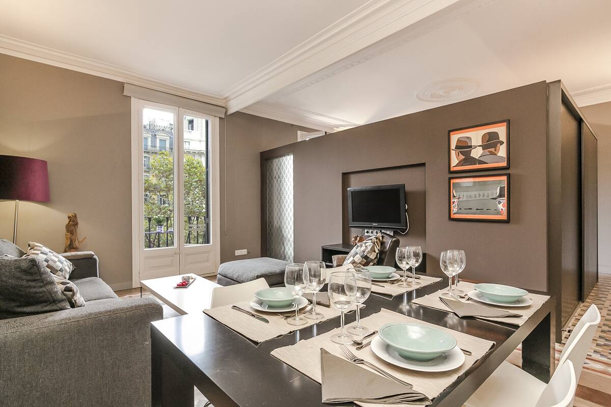 Un salon moderne comprenant un coin repas, un canapé, un téléviseur et un balcon avec vue.