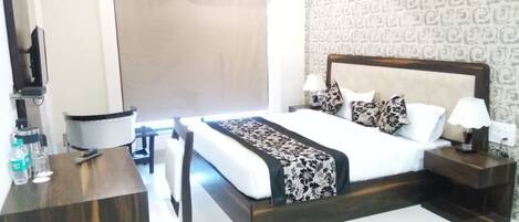 Una habitación de hotel con cama, mesitas de noche, escritorio y una silla.