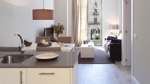 Una cocina moderna con un lavamanos, una zona de comedor con mesa y sillas, y vistas al exterior a través de una ventana.