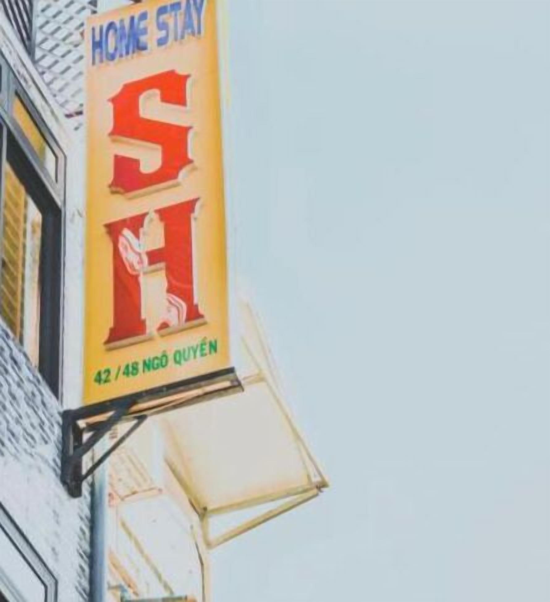 Ein Hotelschild mit der Aufschrift "HOME STAY" und "SH" in großen Lettern sowie der Adresse "42/48 NGÓ QUYEN" darunter.