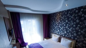 A modern hotel room with a large bed, a desk, and a chair. - Udi Hotel (Çanakkale)