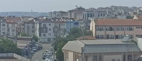 Vista de una calle con edificios, coches estacionados y cielo despejado.