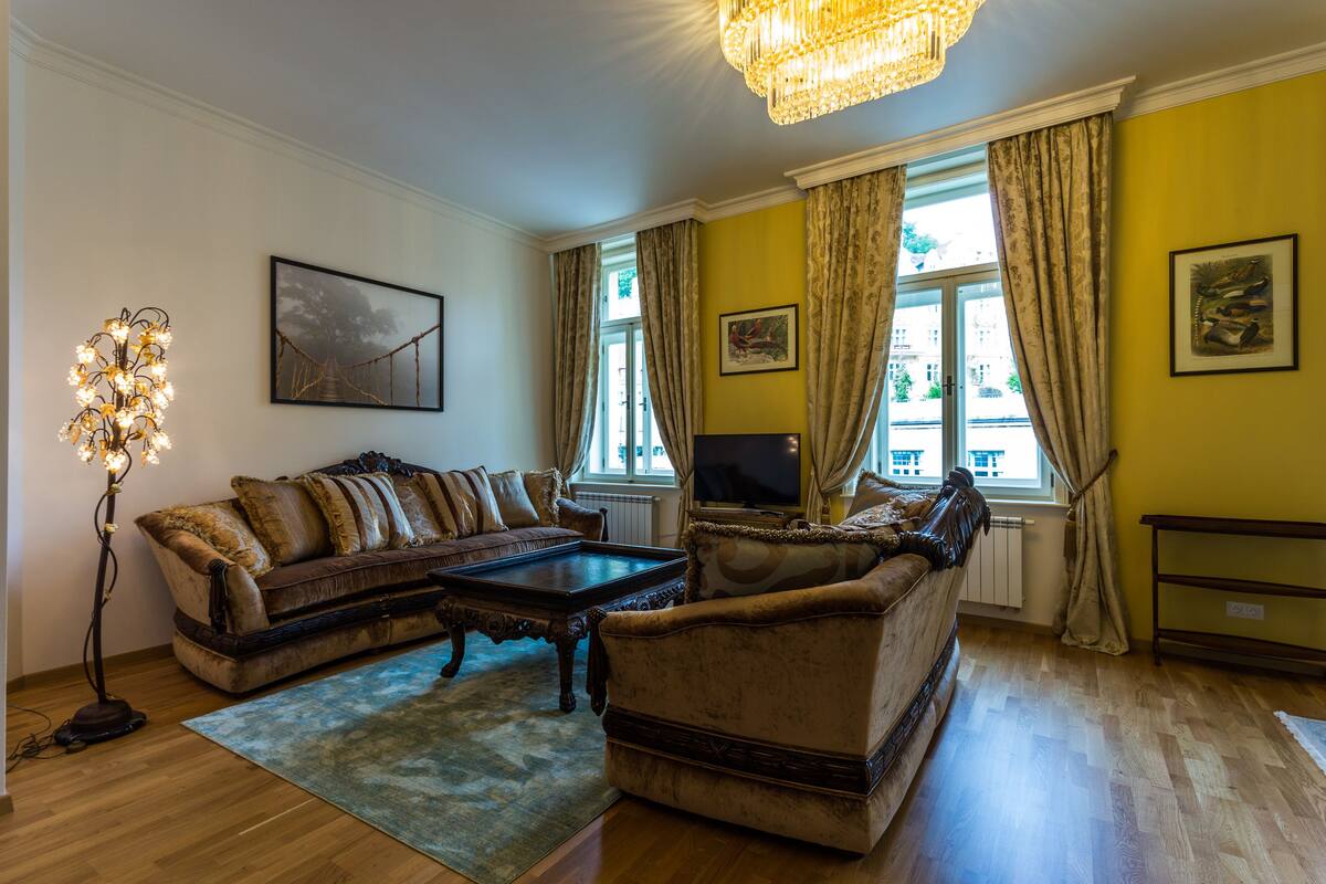 A living room with a sofa set, a coffee table, a floor lamp, and a television.