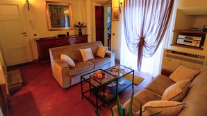 A living room with a sofa, a coffee table, and a television. - Palazzo Mari (San Gimignano)