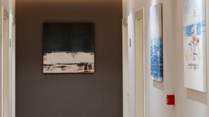A hallway with a neutral color scheme, recessed lighting, and artwork on the walls. - Hotel Alpha (Sarandë)