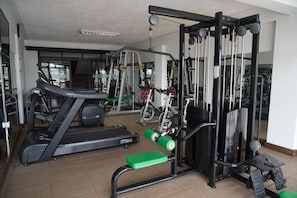 A gym with treadmills, weight machines, and a bench.