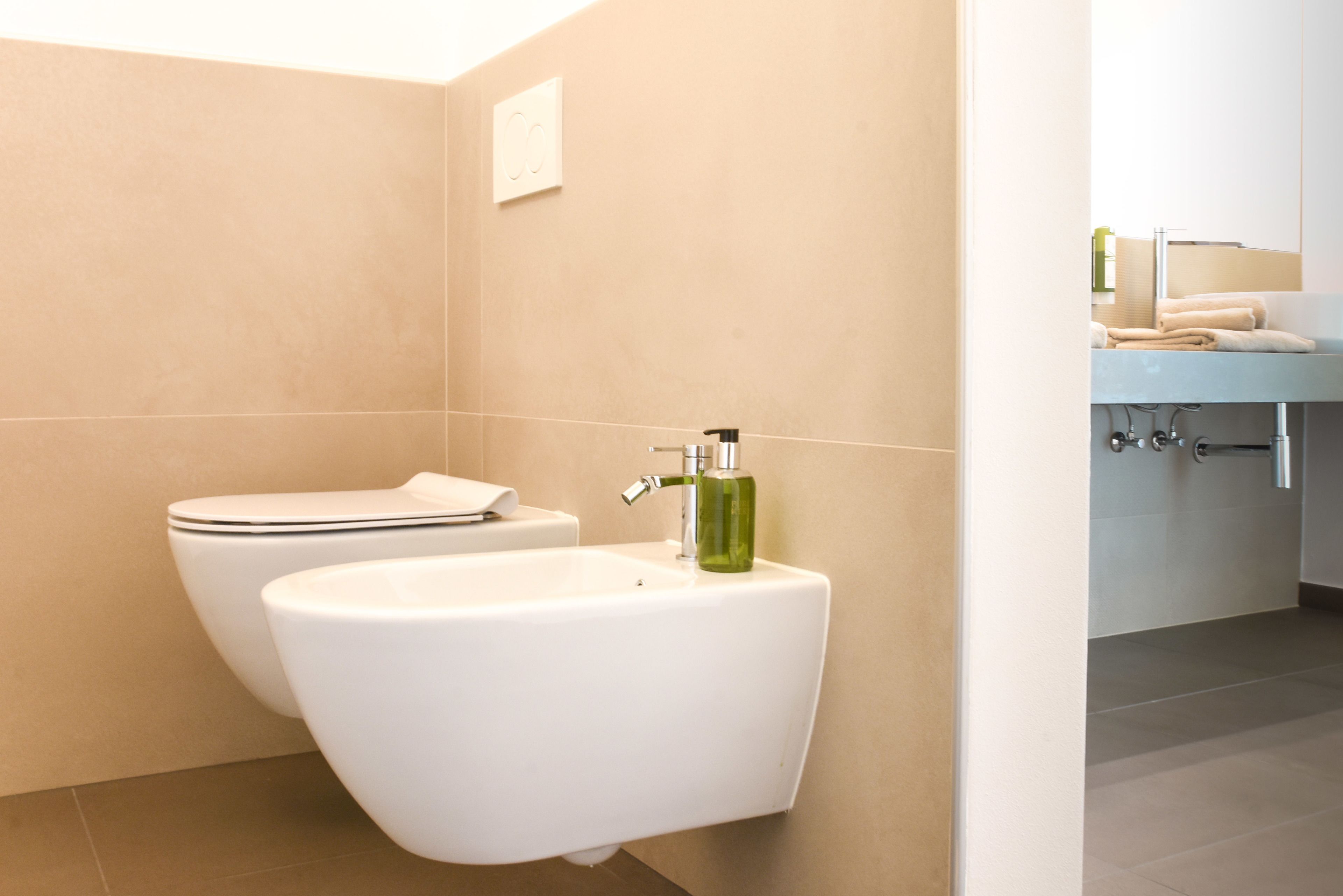 Un baño moderno con inodoro, bidé y lavamanos.