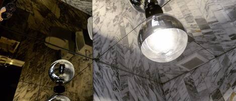 A bathroom with marble floors, a toilet, a sink, and a mirror.