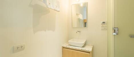 Une salle de bain avec un lavabo blanc, un meuble en bois et un miroir.