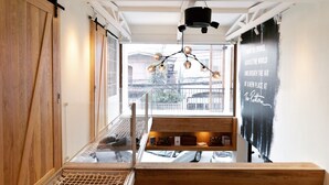 Interior moderno com um banco de madeira, luminária pendente e vista para o exterior.