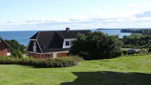 A house with a sloped roof, a chimney, and a view of the sea. - 2 room above (45012) - Apartment 45012 and 45013 (Göhren)