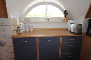 A kitchen with a window, a toaster, and a coffee maker.