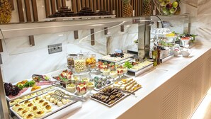 Buffet amb diversos plats i una presentació de fruita.
