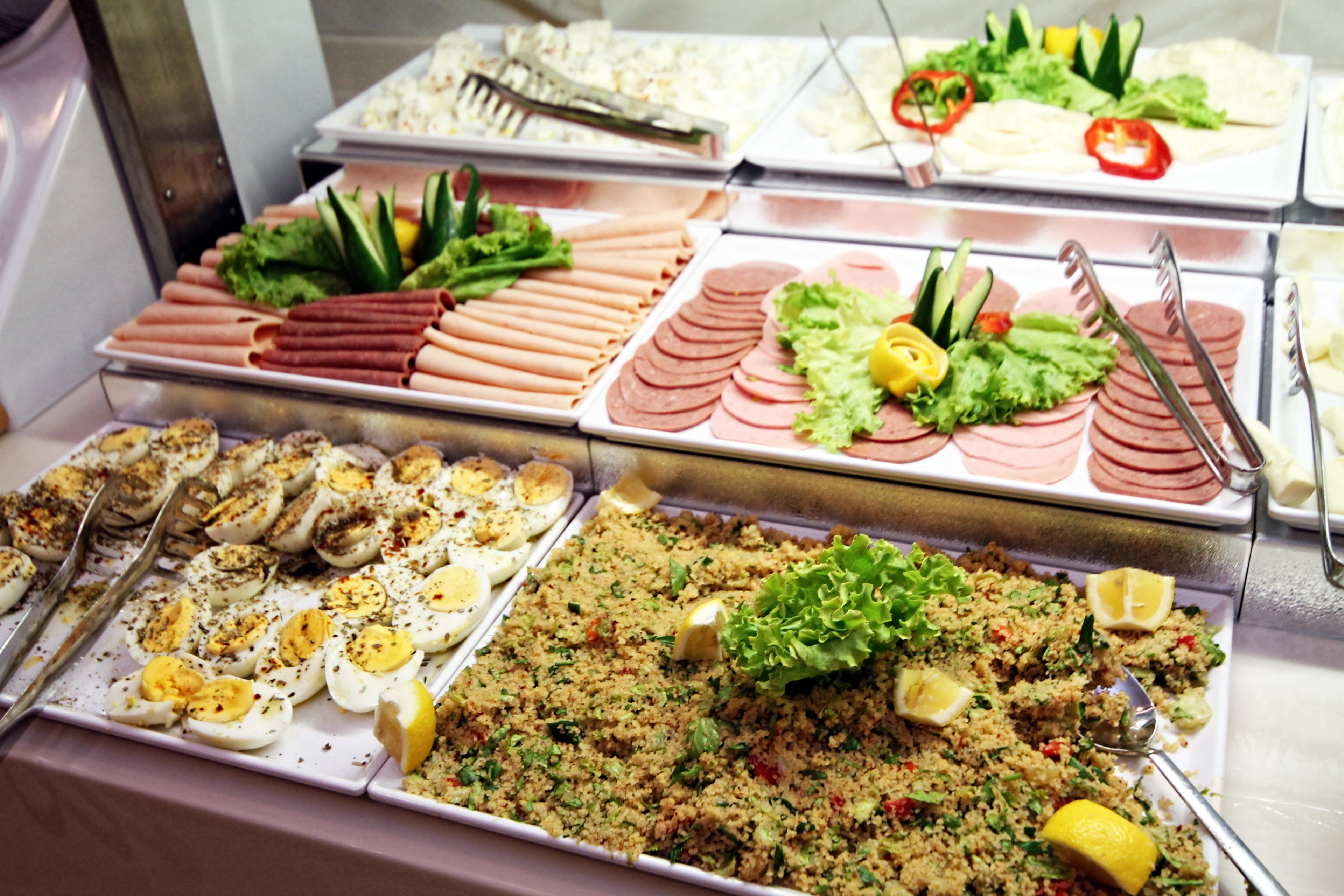 A buffet with various food options including meats, salads, and a couscous dish.
