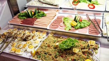 A buffet with various food options including meats, salads, and a couscous dish.