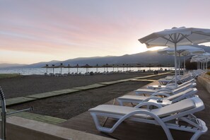 Privatstrand, Liegestühle, Sonnenschirme, Volleyball