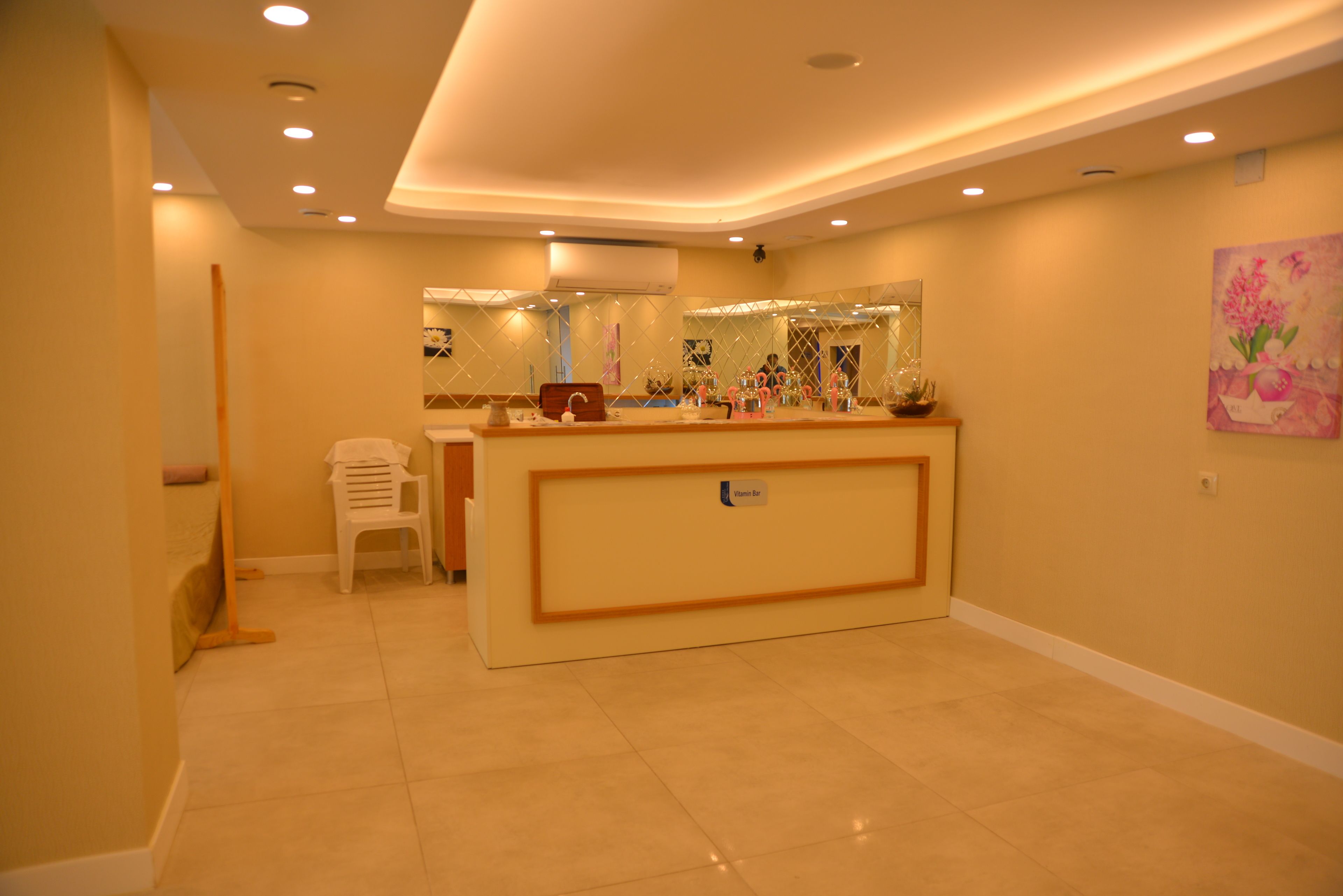 A reception area with a reception desk, a small seating area, and a wall-mounted mirror.