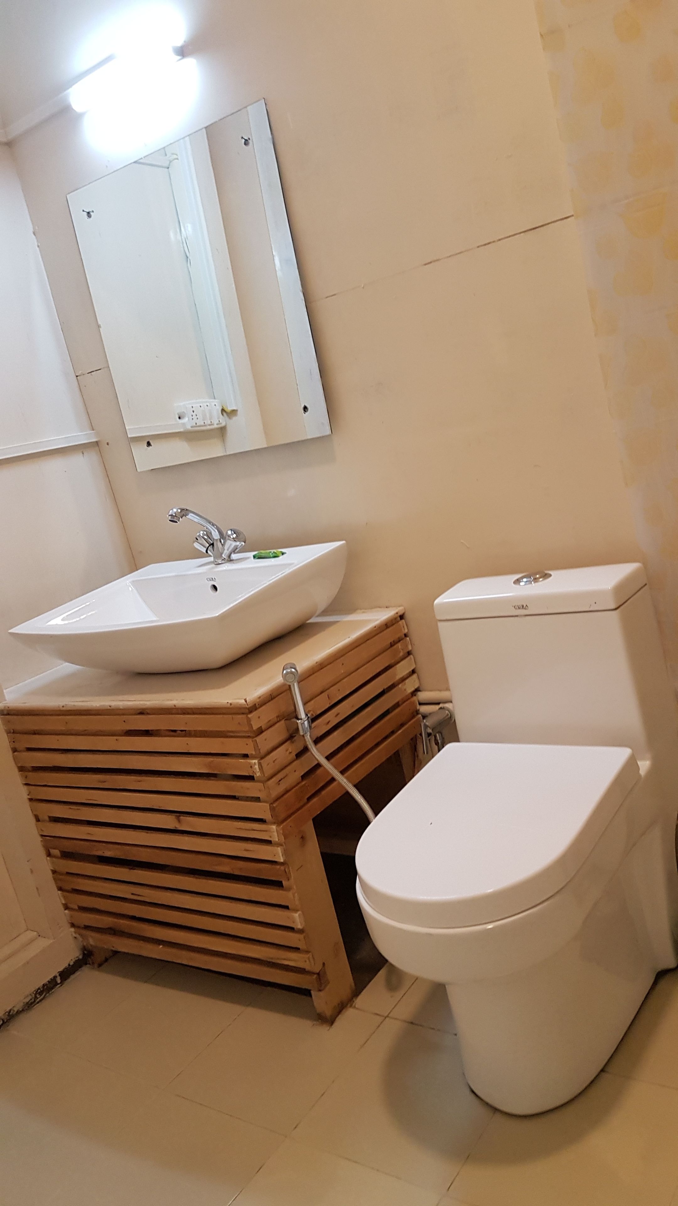 Un baño con un lavamanos blanco, un inodoro y un espejo sobre el lavamanos.