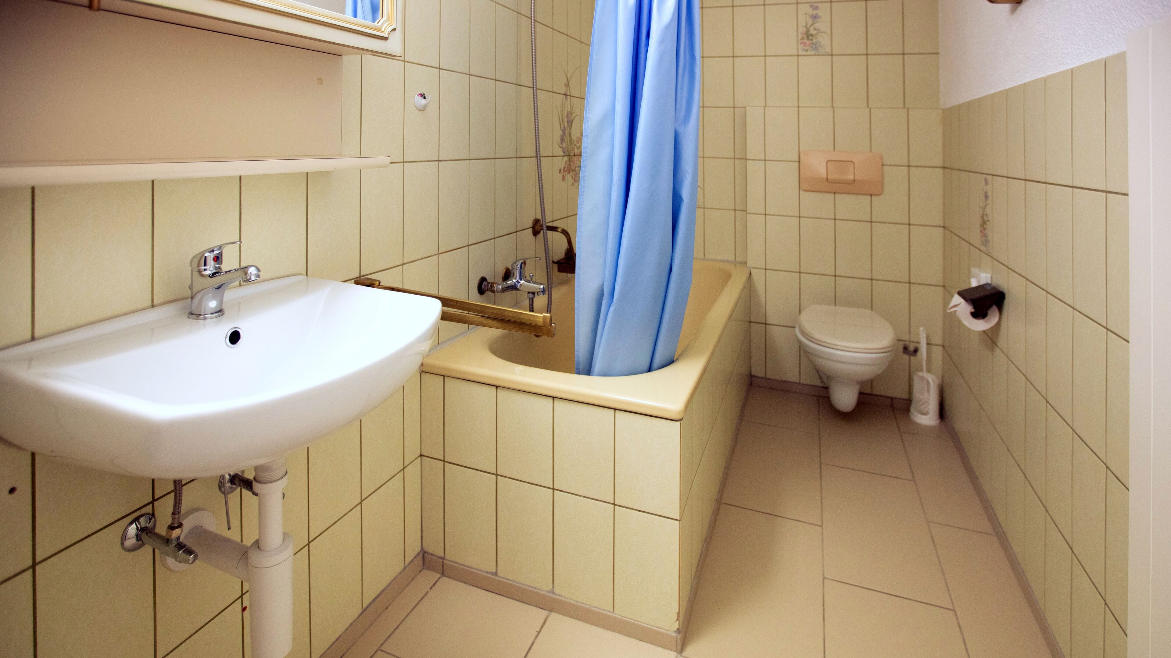 A bathroom with a sink, toilet, and shower curtain.
