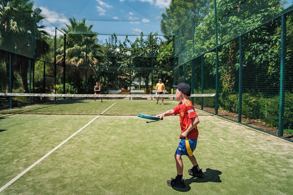 A tennis court with a net, surrounded by a green fence and trees. - La Siesta Salou Resort & Camping (Salou)