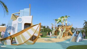 Un terrain de jeux avec une structure de jeu en forme de bateau et une cabane dans les arbres.