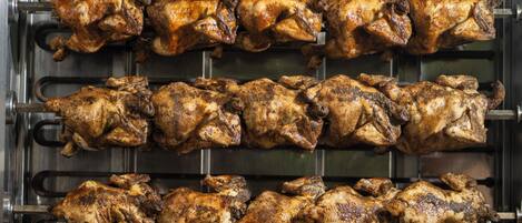 A commercial kitchen with multiple rows of hanging poultry.