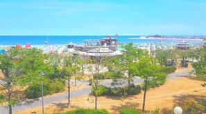 Privat strand, solstolar, parasoller och volleyboll