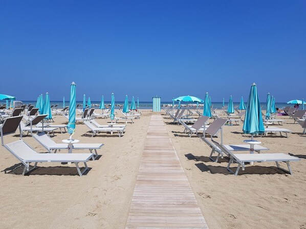 Privatstrand, Liegestühle, Sonnenschirme, Volleyball