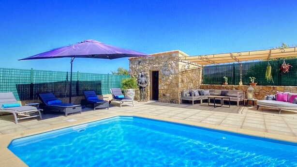 A swimming pool with lounge chairs and umbrellas, a stone wall, and a covered seating area. - Beautiful semi-detached villa of 115 m2, cosy and quiet. (calenzana)