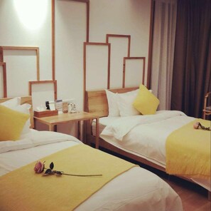 Une chambre d’hôtel avec deux lits, des têtes de lit en bois et une petite table avec des articles de toilette.