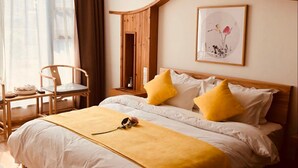 Habitació d'hotel ben ordenada, amb un llit gran, una taula de nit, una cadira i una finestra amb cortines.