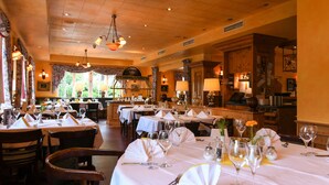 A restaurant with multiple tables set for dining, featuring white tablecloths, wine glasses, and chairs. - Ringhotel Kloevensteen (Schenefeld)