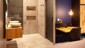 A modern bathroom with a large mirror, two sinks, and a shower area.