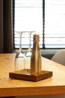 Una mesa de madera con una botella de champán y dos copas sobre una bandeja.