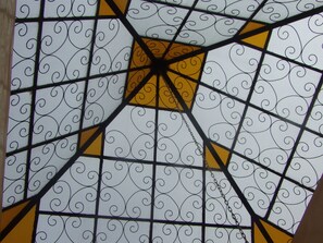 A geometric pattern with a central yellow square and surrounding white panels with black swirls.