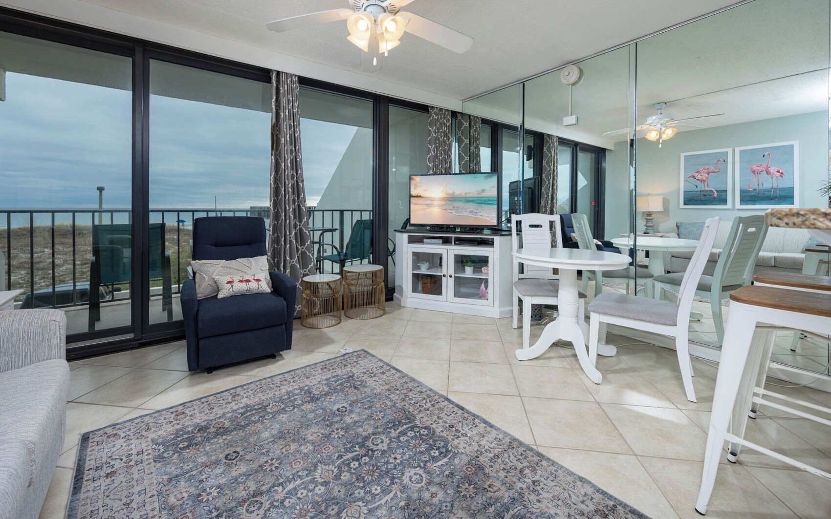 A modern living room with a balcony, a television, and a dining area.
