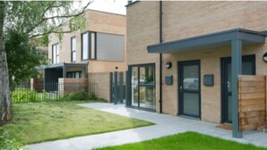 A modern building with a flat roof, large windows, and a covered entrance area. - Tailored Stays  -  Executive Town House (Cambridge)