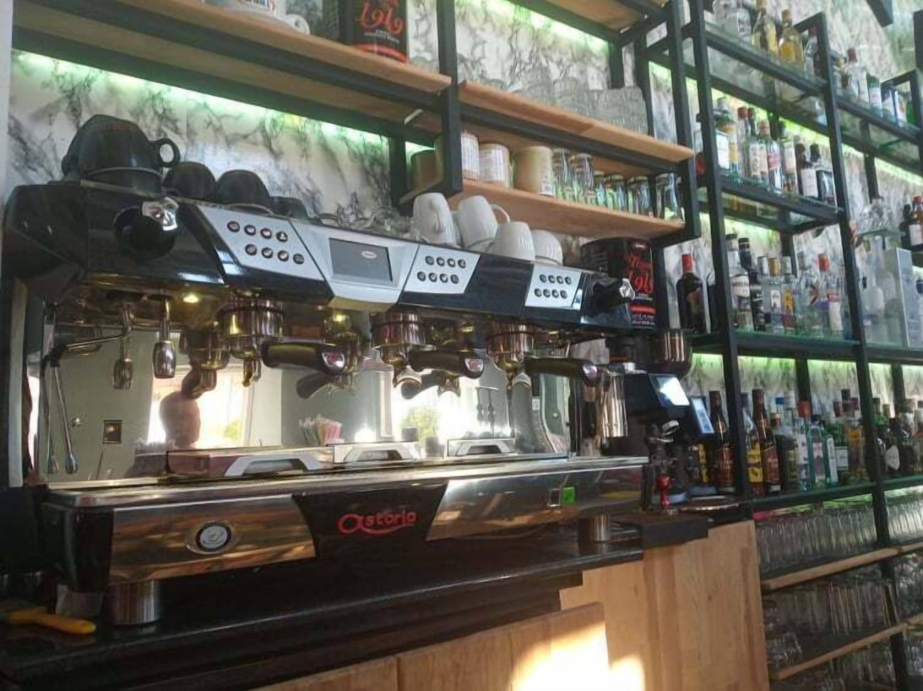 A coffee machine with multiple steam wands and a coffee grinder.