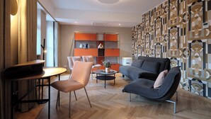 Una sala de estar moderna con un sofá, sillones, una mesa de centro y una estantería.