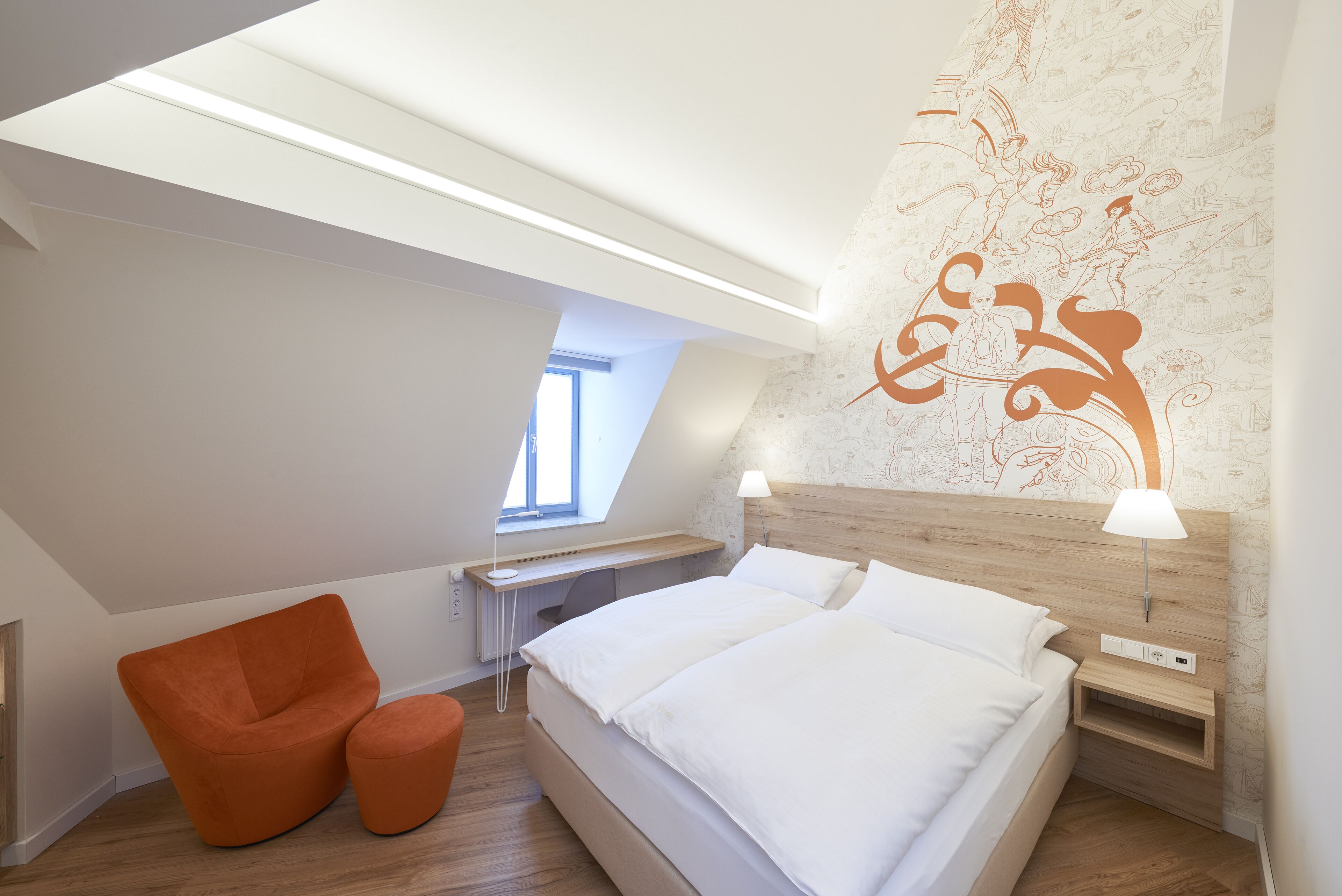 Et moderne soveværelse med ovenlys, en træsenggavl, en seng med hvide sengetøj, en orange lænestol og et skrivebord med en lampe.
