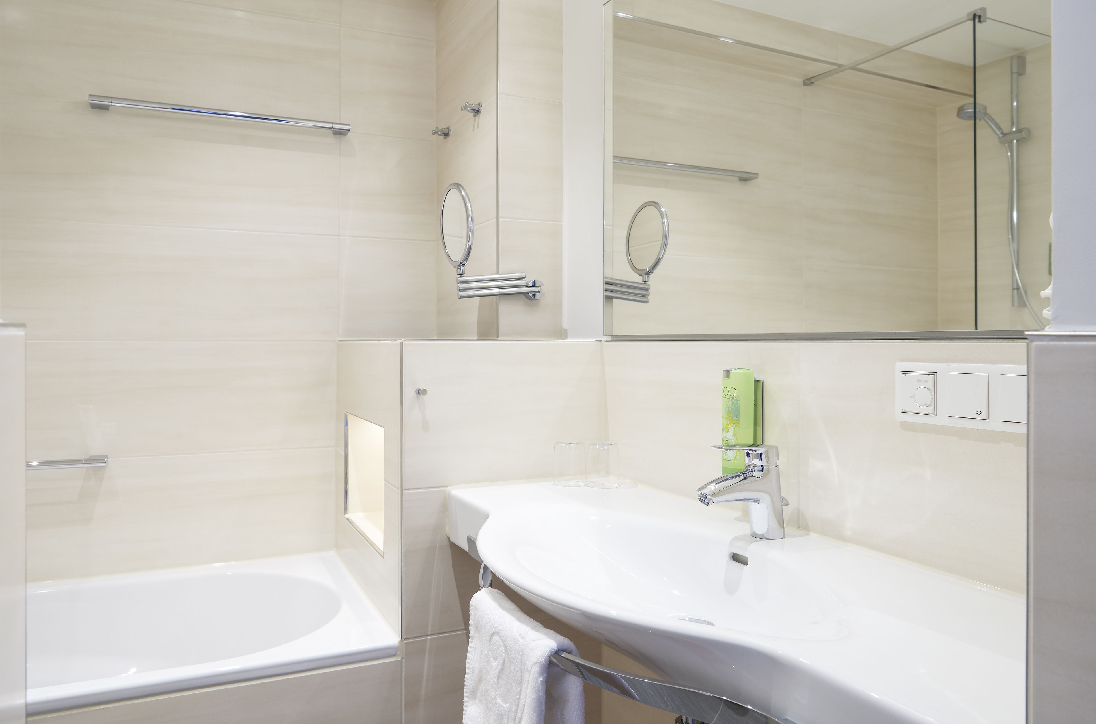 A modern bathroom with a bathtub, a sink with a mirror, and a shower area.