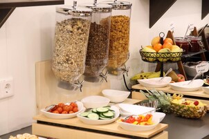 Un bufé de desayuno con diversos alimentos y recipientes.